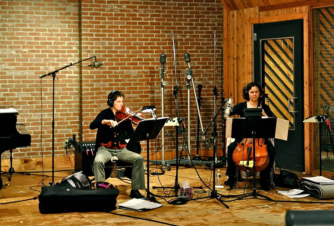 Deux musiciennes enregistrent un violon et un violoncelle en studio